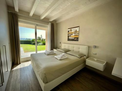 - une chambre avec un grand lit et une grande fenêtre dans l'établissement La Giolosa Gardapartments, à Moniga del Garda