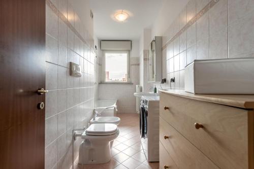 Baño blanco con 2 aseos y lavamanos en Futurismo, en Milán
