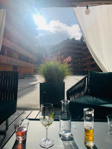 a table with two glasses of wine on a patio at Sunny Stenna Selva 3-room ski-in ski-out apartment right by the slopes & lifts in Flims