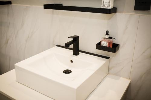 a white bathroom sink with a black faucet at Doran Vineyards in Paarl