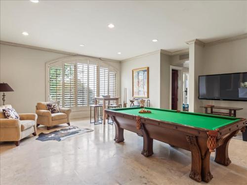 a living room with a pool table and a tv at Lakeside Grande Villa in Alexander City
