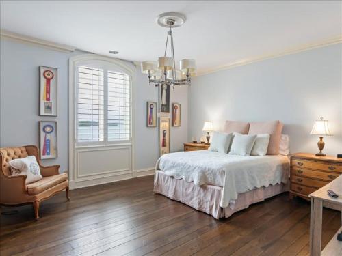 a bedroom with a bed and a chair and a chandelier at Lakeside Grande Villa in Alexander City