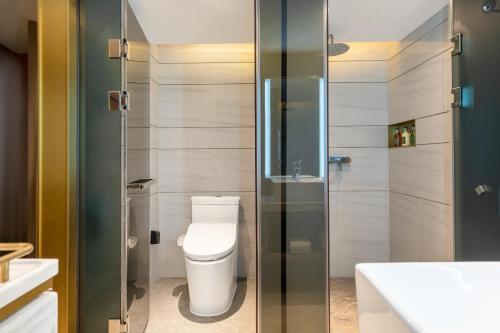 a bathroom with a toilet and a glass shower at Echarm PLUS Hotel Guangzhou Beijing Road Pedestrian Street Dafo Ancient Temple in Guangzhou
