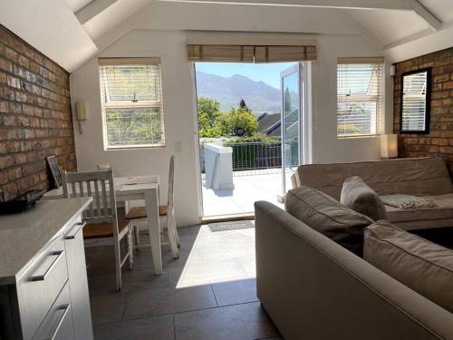 a living room with a couch and a kitchen with a table at Myrtle Loft in Cape Town