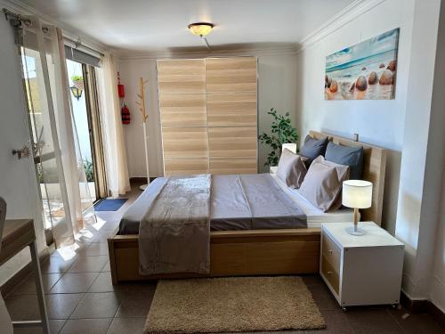 a bedroom with a large bed with a wooden headboard at Cascais Quaint Cottage in Alcabideche