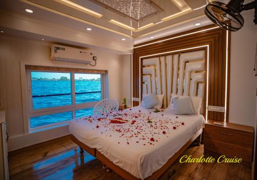 Charlotte Cruise House Boat في أليبي: غرفة نوم مع سرير كبير مع بتلات ورد حمراء عليها