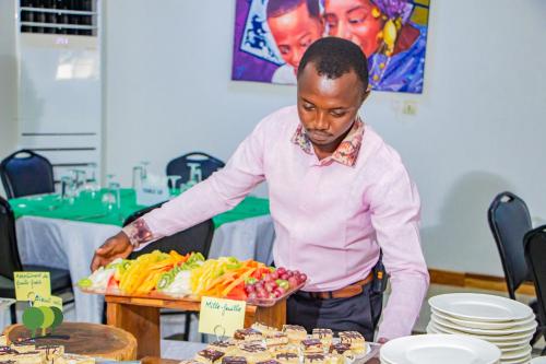 a man reaching for a tray of food on a table at VILLA DE L'INTEGRATION in Ouagadougou