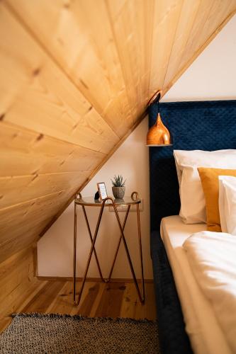 a bedroom with a bed and a wooden ceiling at VALONÉ Villány in Villány