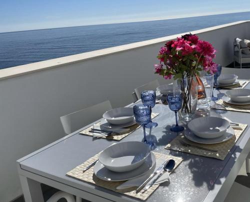 een tafel met borden en glazen en bloemen op een boot bij Sunny penthouse beach apartment with panoramic views in Almuñécar