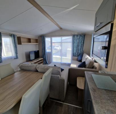 a living room with a couch and a table at Luxuary Static Caravan Sleeps 6 Coopers Beach - Luxurious Get Away in East Mersea