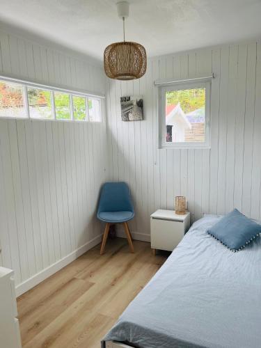 une chambre avec un lit et une chaise bleue dans l'établissement Biscarrosse Lac - Maguide -Modern Chalet, à Biscarrosse