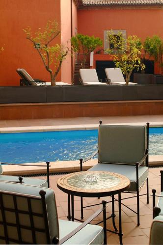 a patio with a table and chairs and a swimming pool at Izan Trujillo in Trujillo