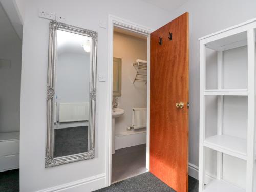 a bathroom with a mirror next to a door at Park Beck in Windermere