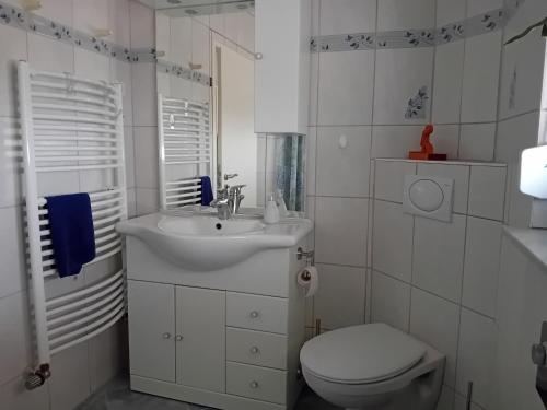 a white bathroom with a sink and a toilet at Ferienhaus Hesse im Frau Holle Land in Germerode