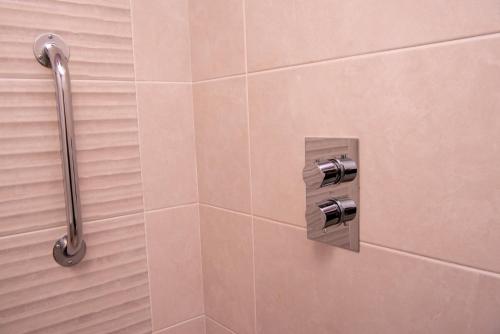 a shower in a bathroom with a tile wall at Donegal House in Donegal