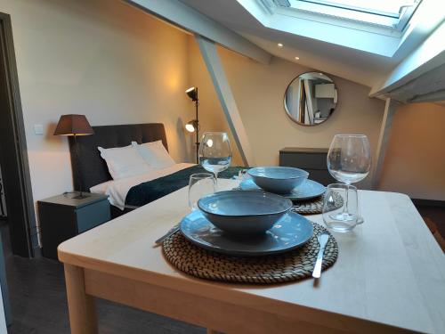 Cette chambre comprend une table avec 2 bols et des verres à vin. dans l'établissement L'Alcôve - Fibre - Clim - Centre-ville, à Albi