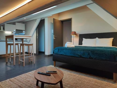 une chambre avec un lit et une table et une cuisine dans l'établissement L'Alcôve - Fibre - Clim - Centre-ville, à Albi