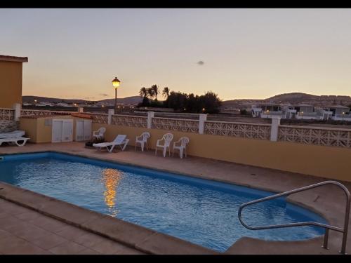 una piscina en la parte superior de un edificio con sillas en 8 Beach Villas Casa Tomas, en Caleta de Fuste
