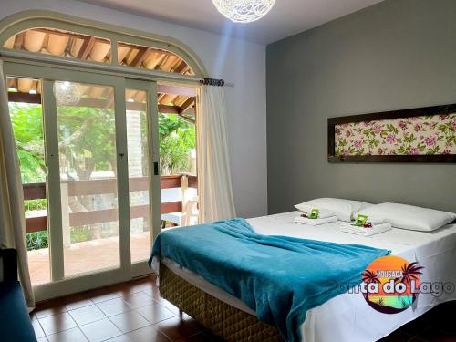 ein Schlafzimmer mit einem Bett und einem großen Fenster in der Unterkunft Pousada Ponta do Lago in Florianópolis