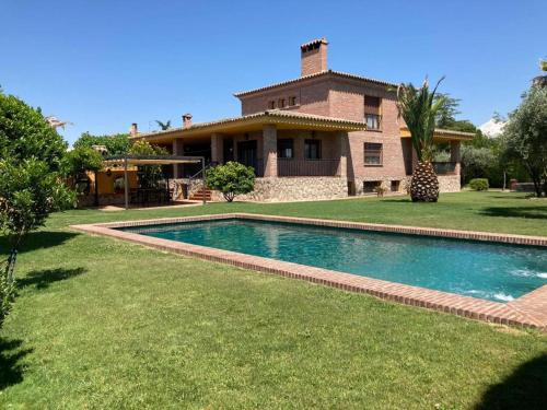 a house with a swimming pool in front of a house at LUXURY Positive House Gran Chaparral Toledo in Pepino