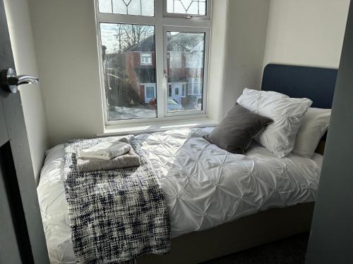 a bed in a room with a window at Stylish & Homely 3 BR House in Sale