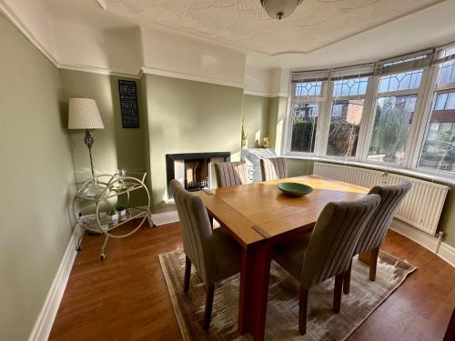 een eetkamer met een houten tafel en stoelen bij Stylish & Homely 3 BR House in Sale