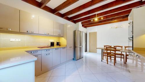 a kitchen with white cabinets and a table and chairs at Les Palmiers in Saint-Denis