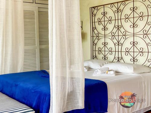 a bedroom with a bed with blue and white sheets at Pousada Ponta do Lago in Florianópolis