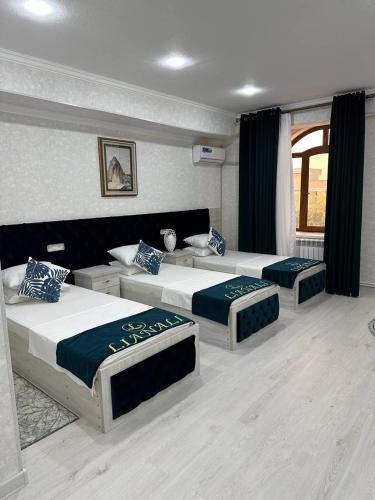 1 dormitorio con 2 camas y ventana en LIANALI Plaza, en Bukhara