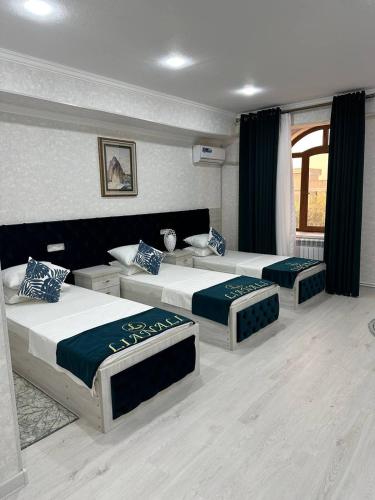 a bedroom with two beds and a window at LIANALI Plaza in Bukhara