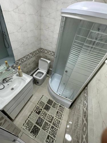 a bathroom with a shower and a toilet and a sink at LIANALI Plaza in Bukhara