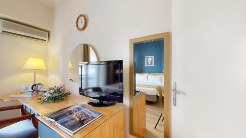 a hotel room with a television and a bedroom at Lucy Hotel in Chalkida
