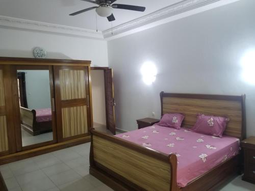 a bedroom with a bed and a ceiling fan at Villa Ndiaye in Ngaparou