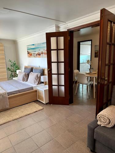 a bedroom with a bed and a table and a door at Cascais Quaint Cottage in Alcabideche