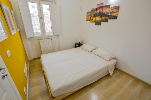 a small bedroom with a white bed and a window at Spada Apartment in Florence