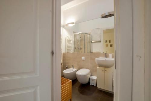 a bathroom with two toilets and a sink and a mirror at Spada Apartment in Florence