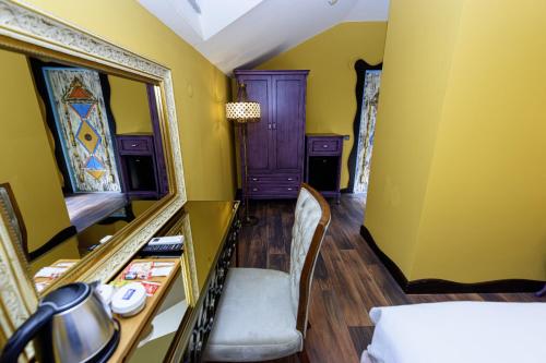 a room with yellow walls and a mirror and a bed at TOK EPİK HOTEL in Bursa