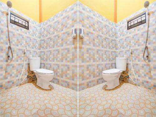 La salle de bains est pourvue de 2 toilettes et d'une douche. dans l'établissement OYO 93087 Wisma Apel Syariah, à Parit