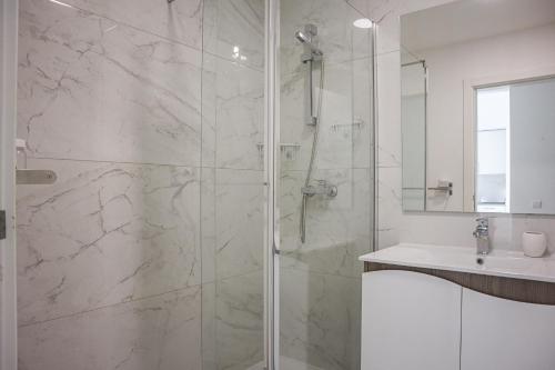baño blanco con ducha y lavamanos en Solar dos Vilarinhos - Free Airco & Wiffi - by bedzy, en Albufeira
