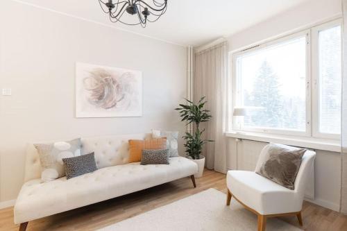 a living room with a white couch and a window at Tunnelmallinen kaksio in Jyväskylä