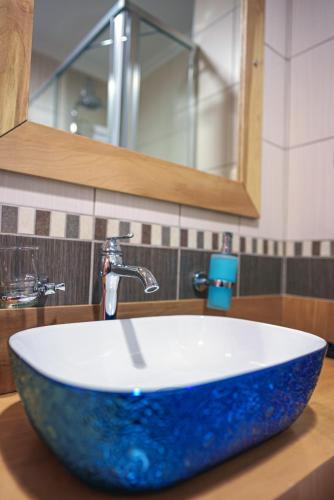 a bathroom sink with a large blue bowl sink at TOK EPİK HOTEL in Bursa