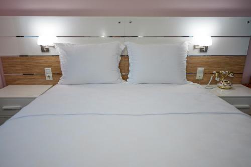 a large bed with white sheets and pillows at TOK EPİK HOTEL in Bursa