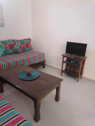 uma sala de estar com um sofá e uma mesa de centro em app à Tamraght prés de la plage de 100m em Agadir