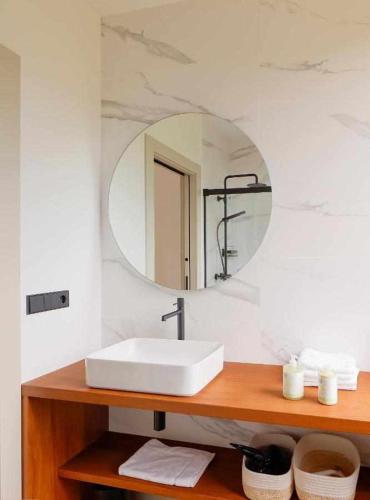 a bathroom with a white sink and a mirror at El Balcón del Sueve - Naturaleza y vistas in Melarde