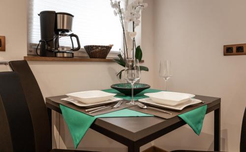 a table with a green table cloth on top at FOR MOMENTS Apartments & Spa in Roßhaupten