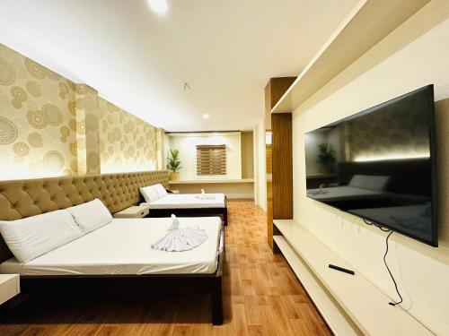 sala de estar con 2 camas y TV de pantalla plana en Dreaming Forest Hotel - Libjo, Batangas en Batangas