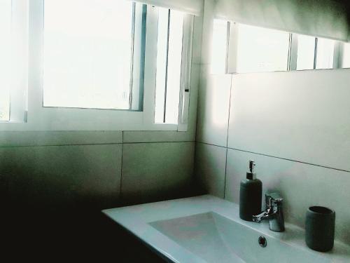 uma casa de banho com um lavatório e uma janela em Enladrillada.Parking Incluido.Cuna del Flamenco em Sevilha