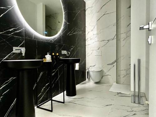 a black bathroom with a sink and a mirror at Phoenix garden in Mons