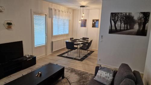 a living room with a couch and a dining room table at Stylish apartment in town centre in Sotkamo