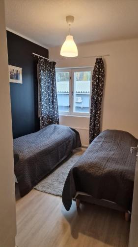 a bedroom with two beds and a window at Stylish apartment in town centre in Sotkamo
